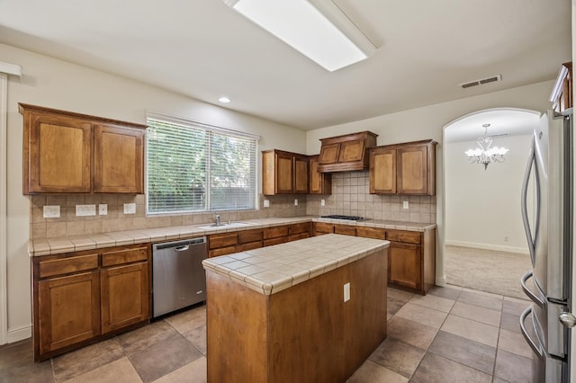 5929 N La Paz Ave, Fresno, CA 93723 - kitchen featuring stainless steel appliances, a chandelier, brown cabinetry, tasteful backsplash, and recessed lighting