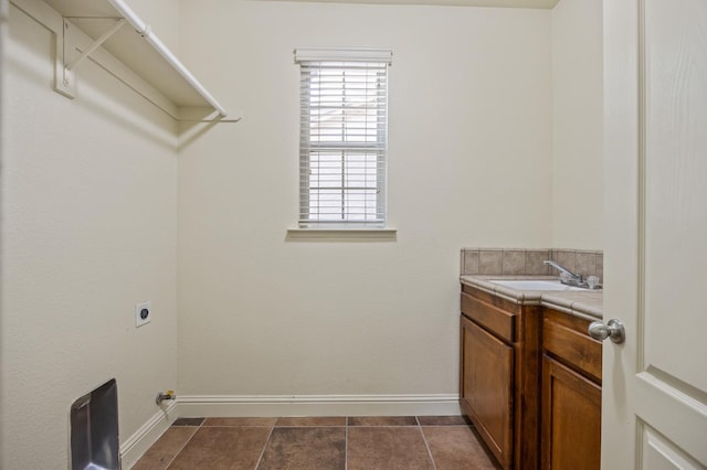 5929 N La Paz Ave, Fresno, CA 93723 - laundry room with hookup for an electric dryer, cabinet space, and dark tile patterned flooring
