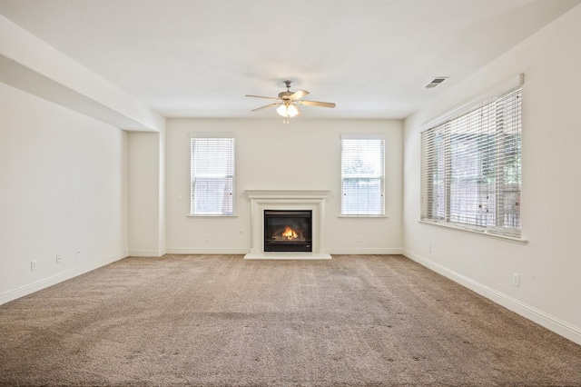 5929 N La Paz Ave, Fresno, CA 93723 - unfurnished living room featuring ceiling fan, healthy amount of natural light, a glass covered fireplace, and carpet floors