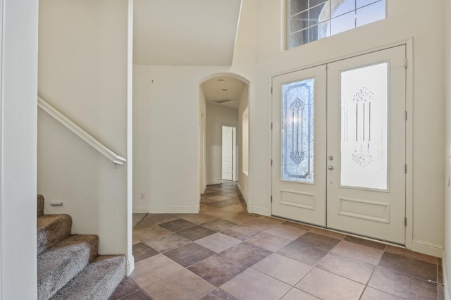 5929 N La Paz Ave, Fresno, CA 93723 - entryway with arched walkways, french doors, a high ceiling, stairway, and stone finish flooring