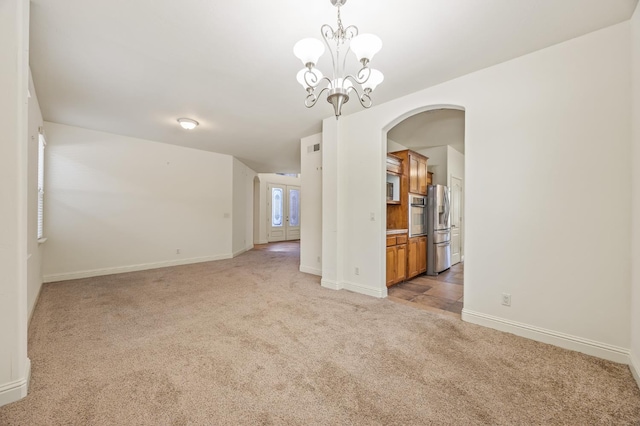 5929 N La Paz Ave, Fresno, CA 93723 - unfurnished room featuring light colored carpet, arched walkways, and a chandelier