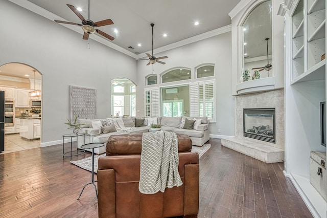 218 W Hubert Ct, Fresno, CA 93711 - living area featuring ceiling fan, arched walkways, a fireplace, crown molding, and a high ceiling