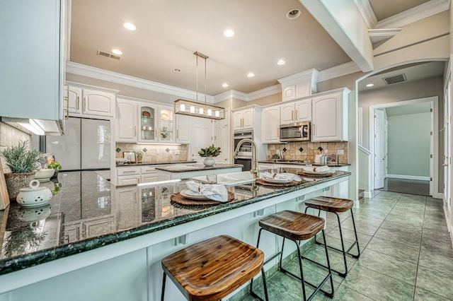 218 W Hubert Ct, Fresno, CA 93711 - kitchen featuring stainless steel appliances, a kitchen breakfast bar, arched walkways, white cabinets, and recessed lighting