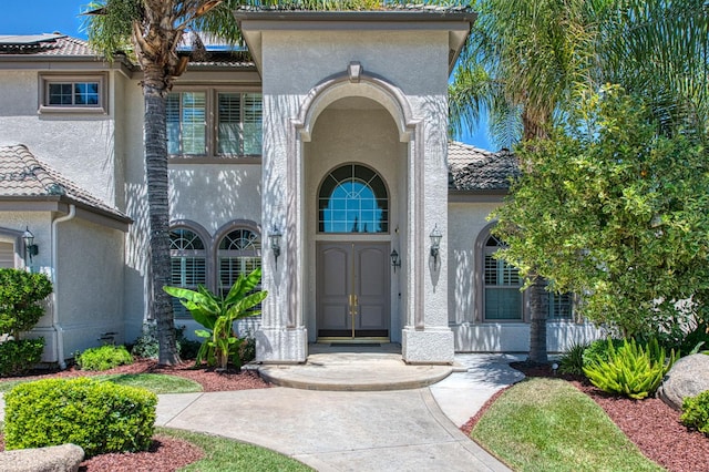 218 W Hubert Ct, Fresno, CA 93711 - view of exterior entry featuring stucco siding and a tile roof