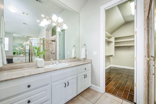 218 W Hubert Ct, Fresno, CA 93711 - bathroom with vaulted ceiling, vanity, a spacious closet, a stall shower, and tile patterned flooring