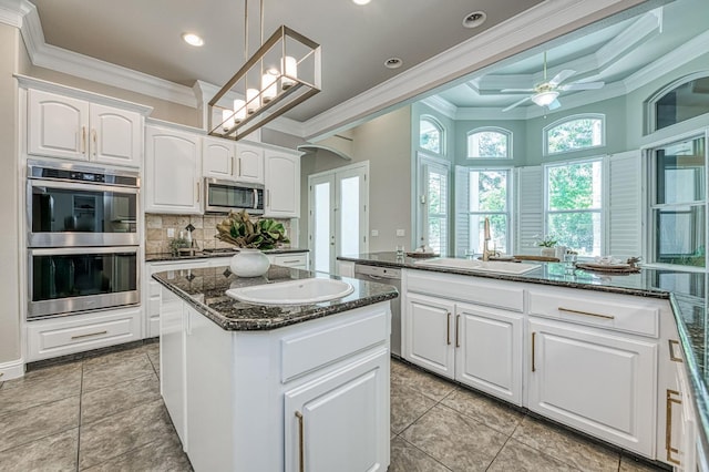 218 W Hubert Ct, Fresno, CA 93711 - kitchen with stainless steel appliances, crown molding, a kitchen island, white cabinetry, and decorative backsplash