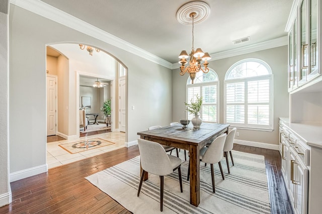218 W Hubert Ct, Fresno, CA 93711 - dining space with arched walkways, dark wood-style floors, ornamental molding, and a chandelier