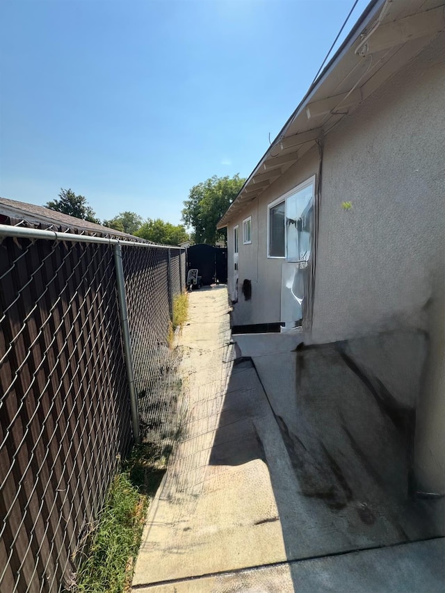 4615 E Hamilton Ave E, Fresno, CA 93702 - view of side of home with a fenced backyard, stucco siding, and a patio