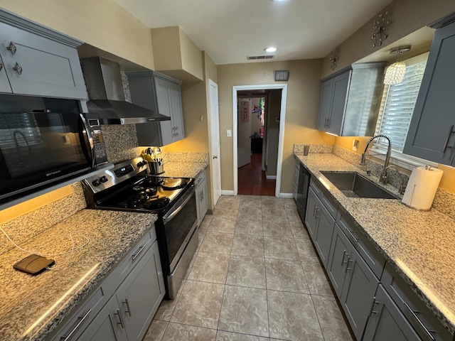 4615 E Hamilton Ave E, Fresno, CA 93702 - kitchen with black appliances, wall chimney range hood, gray cabinetry, light stone counters, and light tile patterned flooring