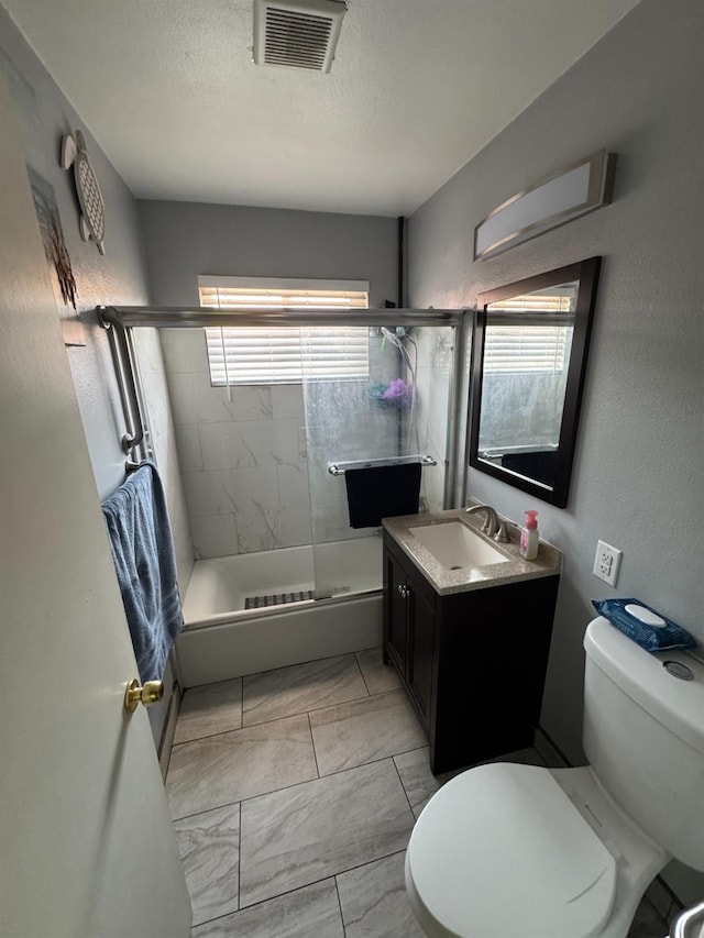 4615 E Hamilton Ave E, Fresno, CA 93702 - full bath with marble finish floors, bath / shower combo with glass door, vanity, and a textured ceiling