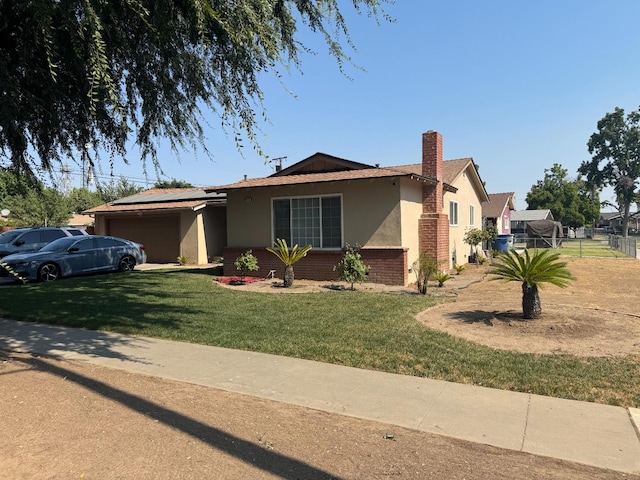 4615 E Hamilton Ave E, Fresno, CA 93702 - single story home featuring a garage, brick siding, stucco siding, a chimney, and roof mounted solar panels