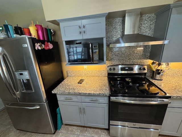4615 E Hamilton Ave E, Fresno, CA 93702 - kitchen with stainless steel appliances, wall chimney exhaust hood, light tile patterned floors, light stone counters, and gray cabinetry