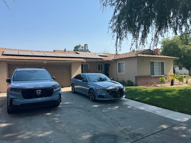 4615 E Hamilton Ave E, Fresno, CA 93702 - ranch-style house featuring stucco siding, driveway, roof mounted solar panels, a front lawn, and an attached garage