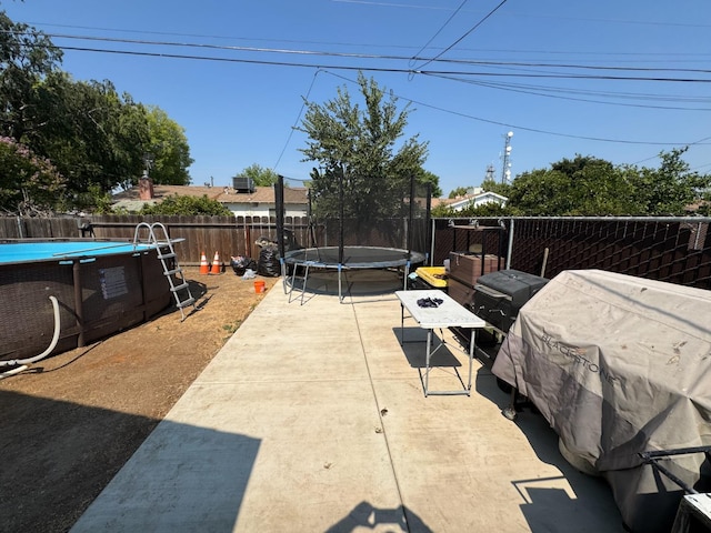 4615 E Hamilton Ave E, Fresno, CA 93702 - fenced backyard featuring a trampoline and a patio
