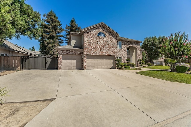 4950 W Minarets Ave, Fresno, CA 93722 - view of front of house with a gate, a garage, driveway, and brick siding