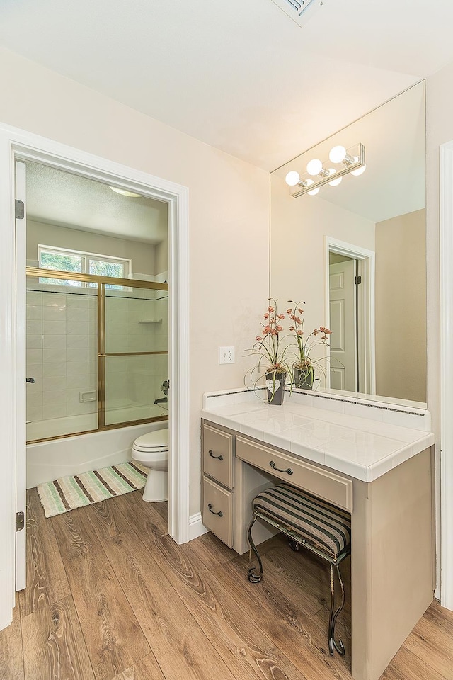 4950 W Minarets Ave, Fresno, CA 93722 - bathroom featuring bath / shower combo with glass door, wood finished floors, and vanity