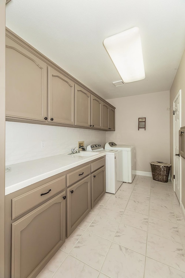 4950 W Minarets Ave, Fresno, CA 93722 - washroom featuring cabinet space, light marble finish flooring, and independent washer and dryer