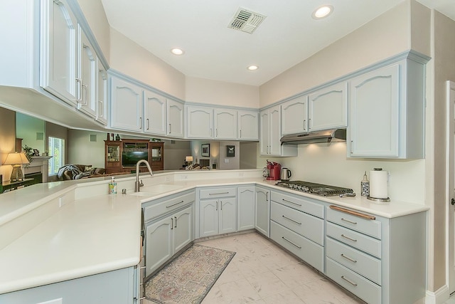 4950 W Minarets Ave, Fresno, CA 93722 - kitchen with stainless steel gas cooktop, light marble finish flooring, under cabinet range hood, recessed lighting, and light countertops