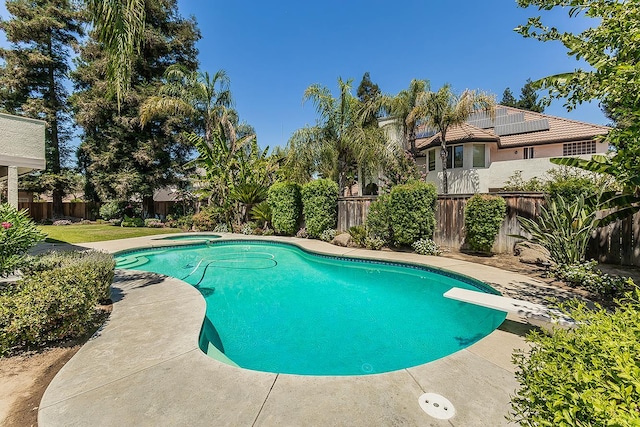 4950 W Minarets Ave, Fresno, CA 93722 - view of pool featuring a diving board, a fenced backyard, and a pool with connected hot tub