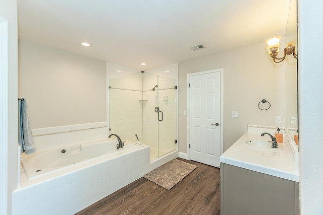 4950 W Minarets Ave, Fresno, CA 93722 - bathroom with a garden tub, wood finished floors, a shower stall, vanity, and recessed lighting