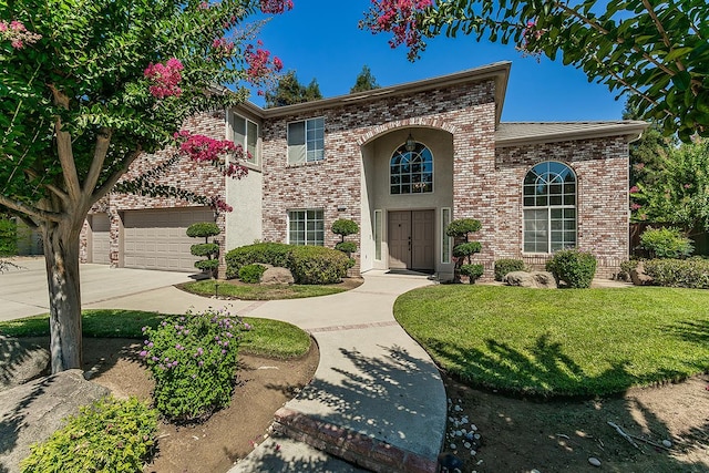 4950 W Minarets Ave, Fresno, CA 93722 - view of front of property with concrete driveway, brick siding, a front lawn, and an attached garage