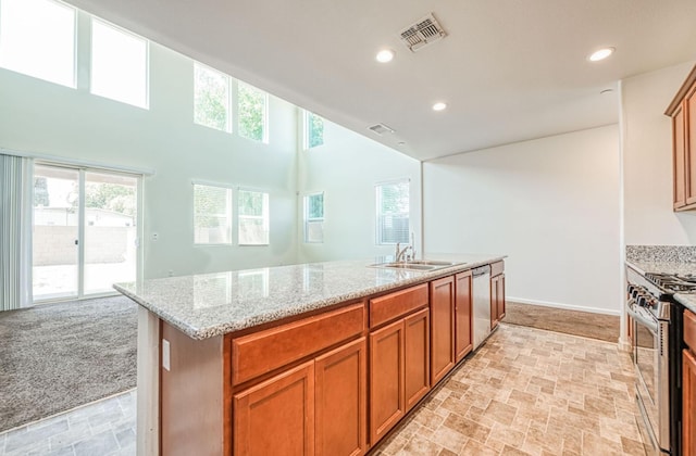 2354 S Garden, Fresno, CA 93725 - kitchen featuring appliances with stainless steel finishes, brown cabinetry, light stone countertops, healthy amount of natural light, and recessed lighting