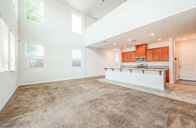 2354 S Garden, Fresno, CA 93725 - unfurnished living room with light colored carpet, plenty of natural light, a high ceiling, and recessed lighting
