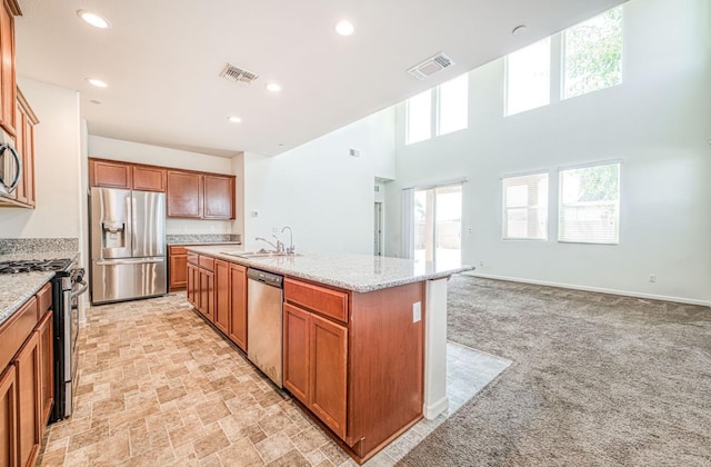 2354 S Garden, Fresno, CA 93725 - kitchen featuring appliances with stainless steel finishes, a kitchen island with sink, light colored carpet, brown cabinets, and recessed lighting