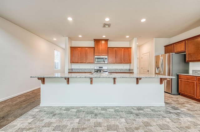 2354 S Garden, Fresno, CA 93725 - kitchen featuring stainless steel appliances, a large island with sink, brown cabinets, a kitchen bar, and recessed lighting