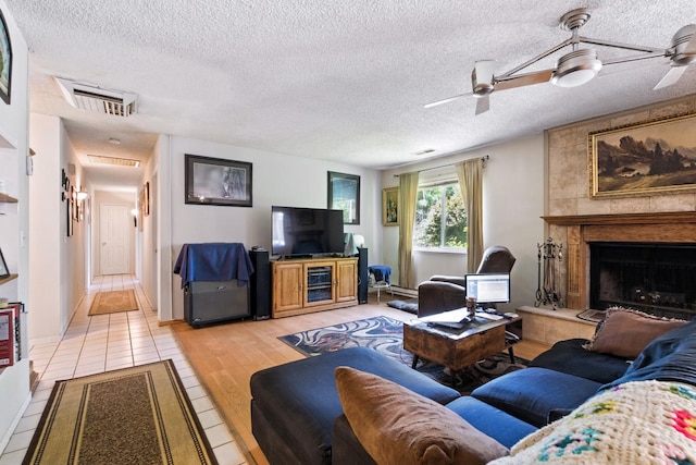 36358 Orange Grove Ave, Madera, CA 93636 - living area with a ceiling fan, a fireplace, a textured ceiling, and light tile patterned flooring