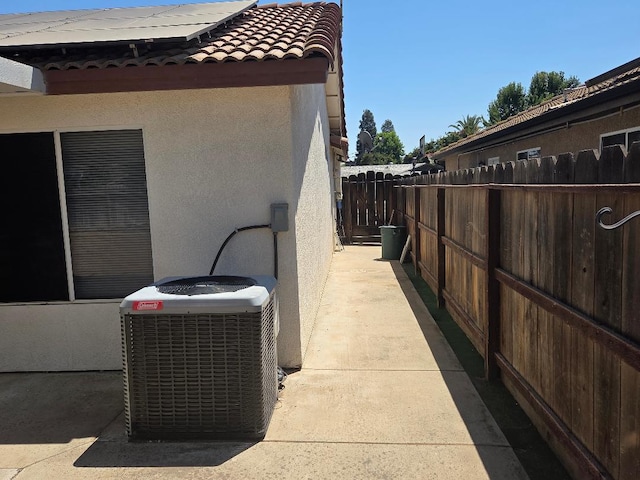 6173 N Marty Ave, Fresno, CA 93711 - view of side of home featuring stucco siding, a tile roof, and roof mounted solar panels
