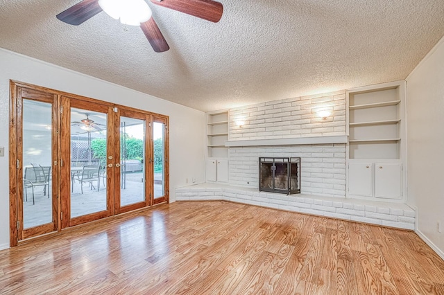 7343 N 4th St, Fresno, CA 93720 - unfurnished living room with a ceiling fan, a textured ceiling, built in shelves, wood finished floors, and a brick fireplace