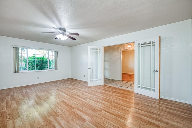 7343 N 4th St, Fresno, CA 93720 - empty room featuring light wood finished floors, ceiling fan, french doors, and a textured ceiling