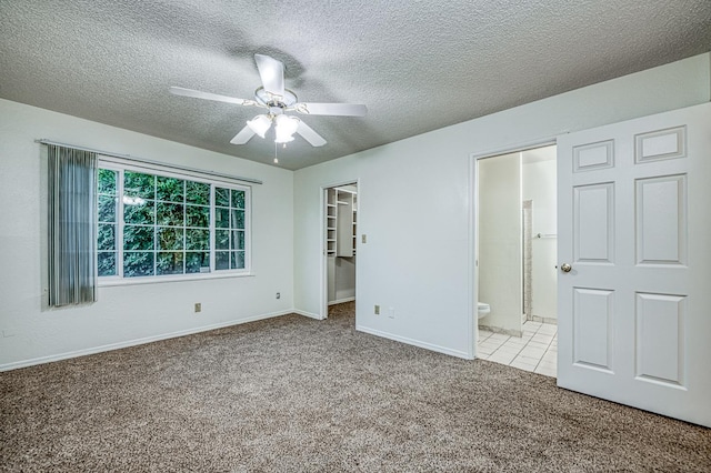 7343 N 4th St, Fresno, CA 93720 - unfurnished bedroom featuring carpet floors, a textured ceiling, a spacious closet, ensuite bath, and a ceiling fan