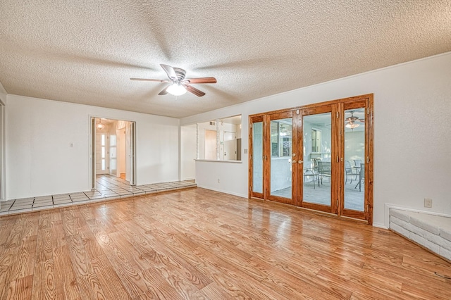 7343 N 4th St, Fresno, CA 93720 - empty room featuring a ceiling fan, light wood finished floors, french doors, and a textured ceiling