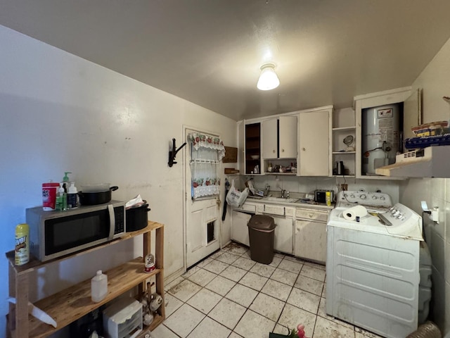 3635 W Cortland Ave, Fresno, CA 93722 - kitchen featuring open shelves, washer / dryer, stainless steel microwave, light countertops, and light tile patterned floors
