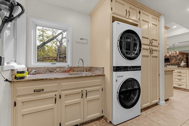 36522 Mudge Ranch Rd, Coarsegold, CA 93614 - laundry area featuring stacked washing machine and dryer, cabinet space, recessed lighting, light tile patterned floors, and a chandelier