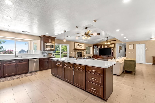 6421 S Greenwood Ave, Del Rey, CA 93616 - kitchen with stainless steel appliances, light countertops, a fireplace, open floor plan, and a ceiling fan