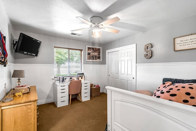 6421 S Greenwood Ave, Del Rey, CA 93616 - carpeted bedroom featuring a ceiling fan, a textured ceiling, a closet, and wainscoting