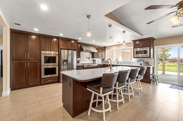 6421 S Greenwood Ave, Del Rey, CA 93616 - kitchen with stainless steel appliances, wall chimney exhaust hood, light countertops, recessed lighting, and a breakfast bar area
