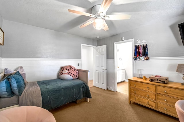 6421 S Greenwood Ave, Del Rey, CA 93616 - carpeted bedroom with wainscoting, ensuite bathroom, a ceiling fan, and a textured ceiling