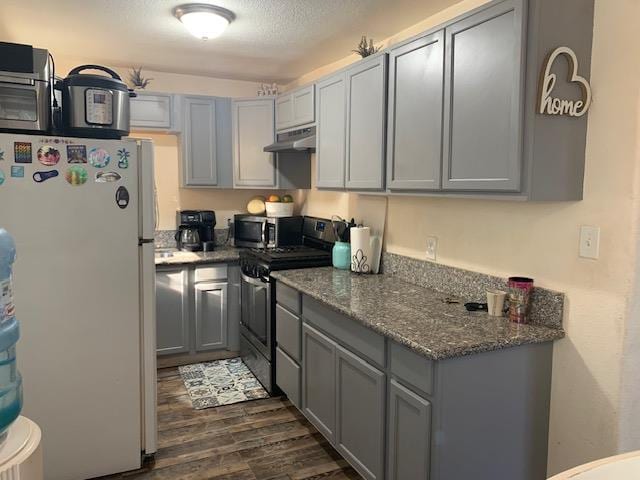3614 E Washington Ave, Fresno, CA 93702 - kitchen with appliances with stainless steel finishes, gray cabinetry, under cabinet range hood, dark wood-type flooring, and dark stone counters