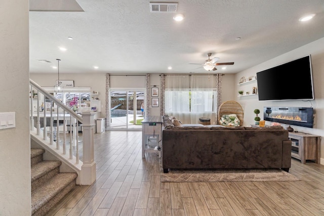 6236 E Garland Ave, Fresno, CA 93727 - living room with wood finished floors, a ceiling fan, stairs, recessed lighting, and a textured ceiling
