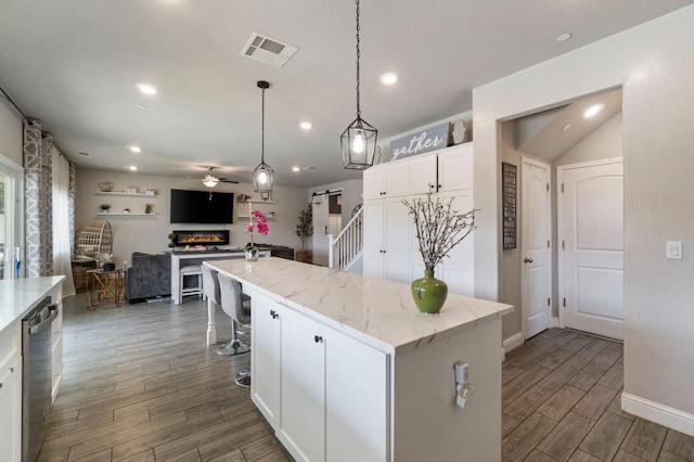 6236 E Garland Ave, Fresno, CA 93727 - kitchen with ceiling fan, wood finished floors, white cabinets, a center island, and dishwasher