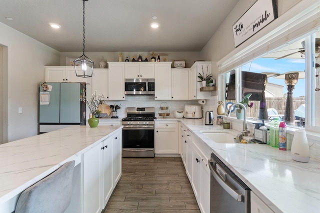 6236 E Garland Ave, Fresno, CA 93727 - kitchen featuring appliances with stainless steel finishes, white cabinetry, decorative backsplash, light stone countertops, and recessed lighting