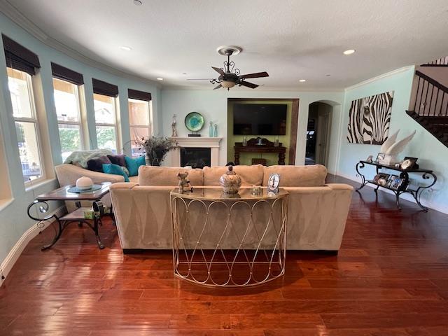 2291 E Prestwick Ave, Fresno, CA 93730 - living area with ceiling fan, a fireplace, recessed lighting, arched walkways, and crown molding