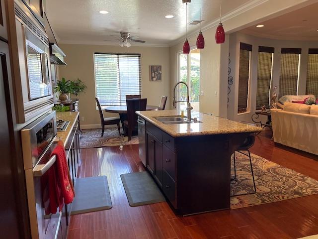 2291 E Prestwick Ave, Fresno, CA 93730 - kitchen with stainless steel appliances, open floor plan, a breakfast bar, dark wood finished floors, and ceiling fan
