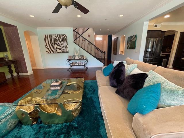 2291 E Prestwick Ave, Fresno, CA 93730 - living area with arched walkways, crown molding, stairway, a ceiling fan, and wood finished floors