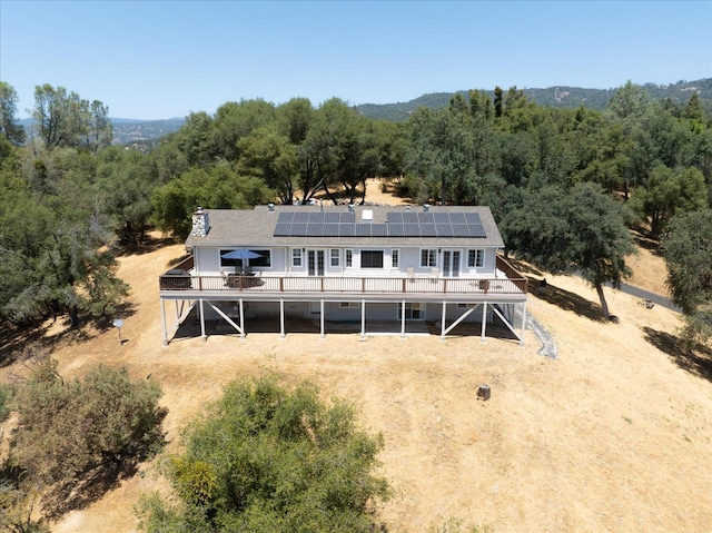 39397 Moonray Ln, Oakhurst, CA 93644 - rear view of house with a deck, a forest view, solar panels, and stairway