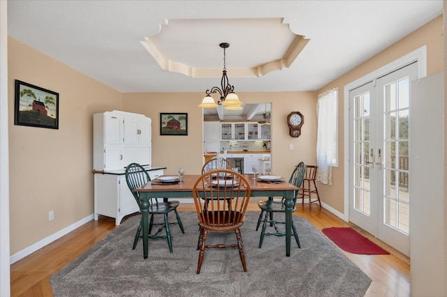 39397 Moonray Ln, Oakhurst, CA 93644 - dining space with french doors, a raised ceiling, light wood-type flooring, and a chandelier